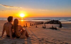 Pareja mirando el amancecer en el Balneario Marisol, provincia de Buenos Aires, Argentina